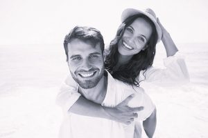 Mujer y hombre abrazados sonriendo a cámara. Un ejemplo de que conocer hombres solteros con Harmony funcionará.